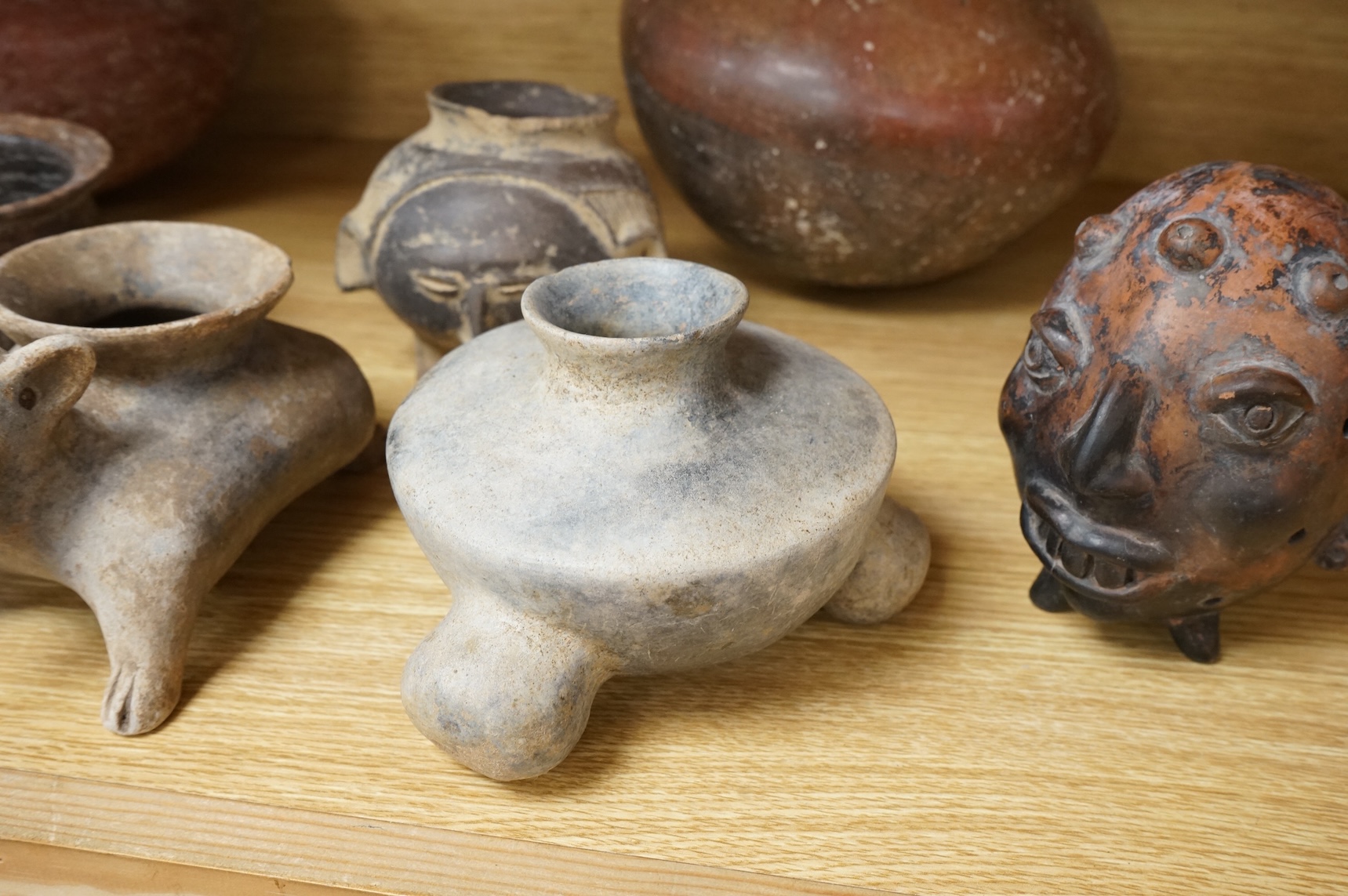 A collection of various South American vessels some in the form of grotesque heads, largest 24cm wide
